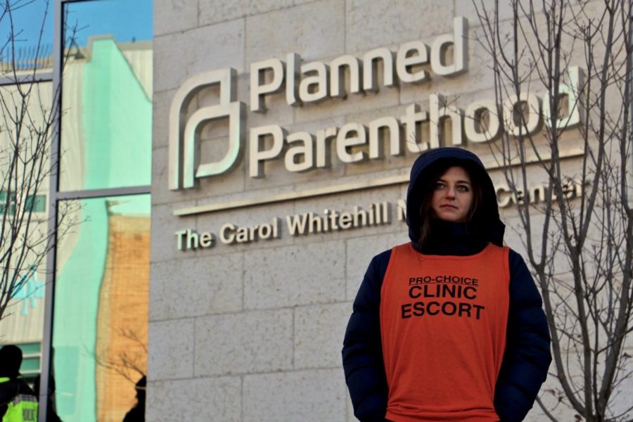 A clinic worker stands outside a Planned Parenthood, acting as an escort for visiting patients.