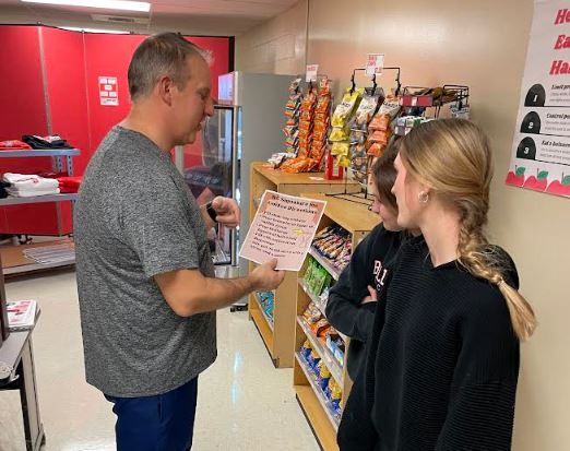 Mr. Myers trains students to run the student store during Raider period.