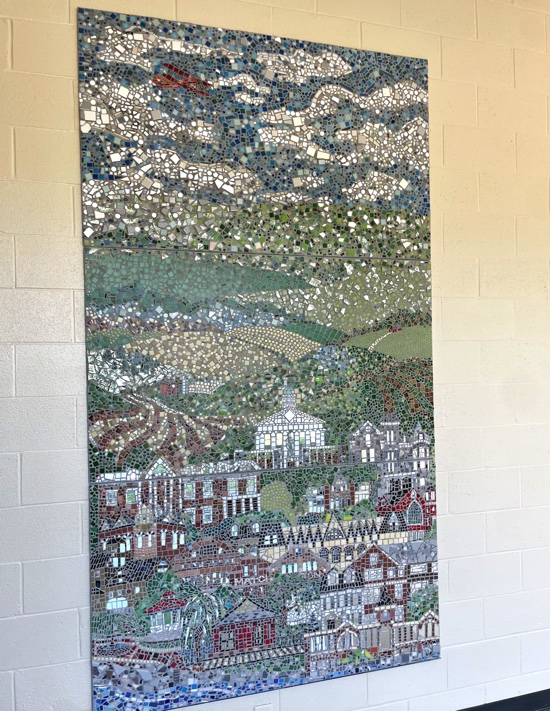 The final mosaic, consisting of three separate panels, hangs in the hallway facing the front of the school. 